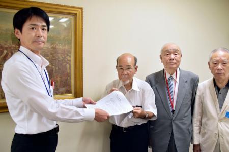 　都職員（左端）に要請書を手渡す宮川泰彦氏ら＝３１日午後、東京都新宿区