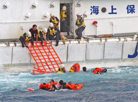 　船から海に投げ出され、海上保安庁の巡視船に救助される人たち＝１６日午後、沖縄県・下地島沖（第１１管区海上保安本部提供）