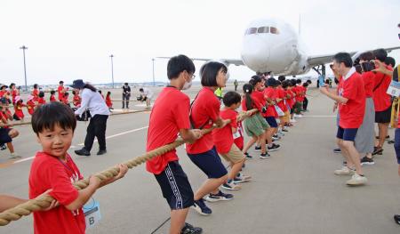 　成田空港で開かれたイベントで、ジェット機を綱で引っ張る子どもたち＝１７日午前