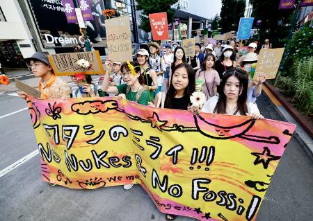 　再エネ社会や脱原発を訴え、東京・渋谷の街頭をパレードする人たち＝１８日午後