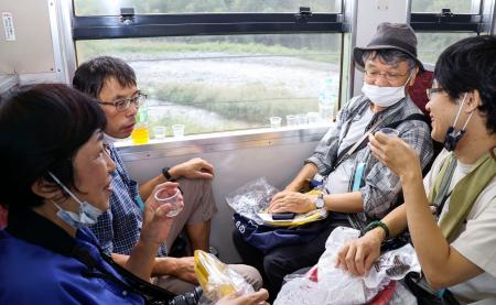 　特別列車「呑み鉄鈍行ちどり足」号で、地酒を楽しむ乗客＝２４日午前、広島県内