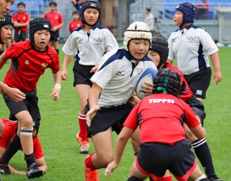 　ラグビーを通じて震災を学ぶイベントでプレーする児童ら＝３０日午後、岩手県釜石市の「釜石鵜住居復興スタジアム」