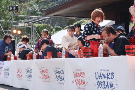 　「わんこそば世界大会」でそばを食べる参加者ら＝１日午後、盛岡市