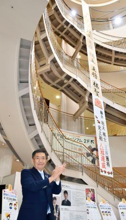 　藤井聡太八冠の地元・愛知県瀬戸市の川本雅之市長（手前）のかけ声とともに掲示された、快挙をたたえる垂れ幕＝１２日午前