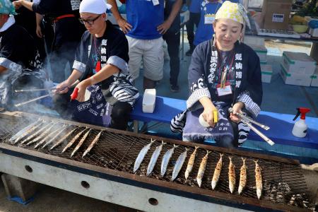 　「目黒のさんま祭」でサンマを振る舞うスタッフ＝８日、東京都目黒区