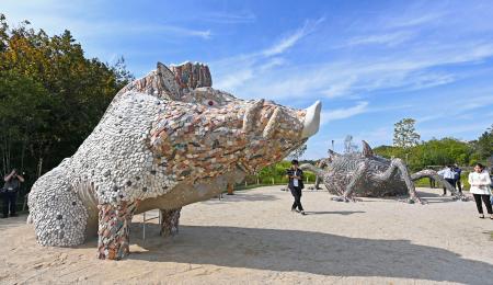 　報道陣に公開されたジブリパークの新エリア「もののけの里」。左が「乙事主」の滑り台、右奥が「タタリ神」のオブジェ＝２５日午前、愛知県長久手市