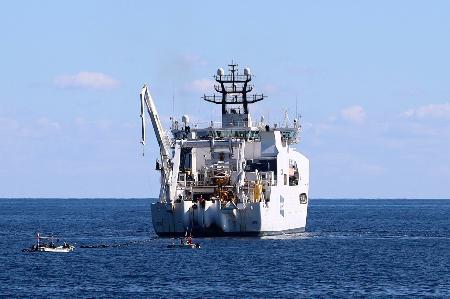 　海底ケーブルを陸上局に接続する作業のため、高知県室戸市の沖合に停止する船＝２９日午前