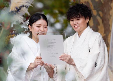 　結婚式で誓いの言葉を述べるみえさん（右）とかよさん＝４日正午ごろ、福岡市