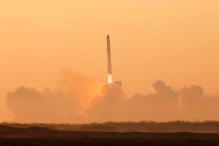 　１８日、米テキサス州のスペースＸ施設から打ち上げられたスーパーヘビーロケット。上部が宇宙船スターシップ（ロイター＝共同）