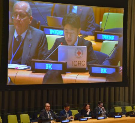 　核兵器禁止条約の第２回締約国会議で発言する高垣慶太さんを映すスクリーン＝１１月３０日、米ニューヨーク（共同）
