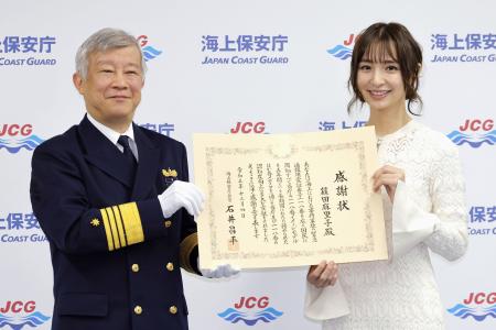 　海保の石井昌平長官（左）から感謝状を受け取り、記念写真に納まる元ＡＫＢ４８メンバーで俳優の篠田麻里子さん＝４日午前、東京・霞が関