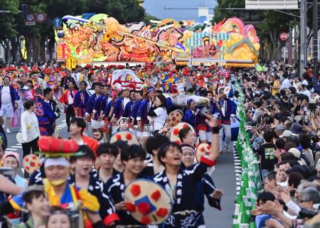 　「東北絆まつり」のパレードで一緒に歩く各県の踊り手ら。中央は福島わらじまつり、奥は青森ねぶた祭＝６月、青森市