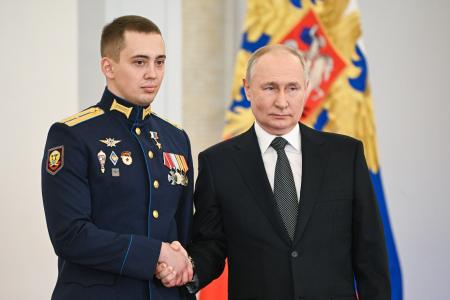 　８日、モスクワのクレムリンで、ロシア軍将校（左）と握手するプーチン大統領（タス＝共同）