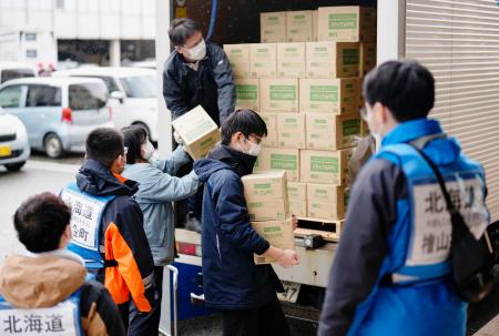 　石川県珠洲市役所前で支援物資を運ぶ北海道からの応援職員ら＝２３日
