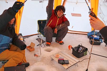 　氷上ワカサギ釣りが解禁され、テントの中で笑顔を見せる人たち＝３１日朝、盛岡市の岩洞湖