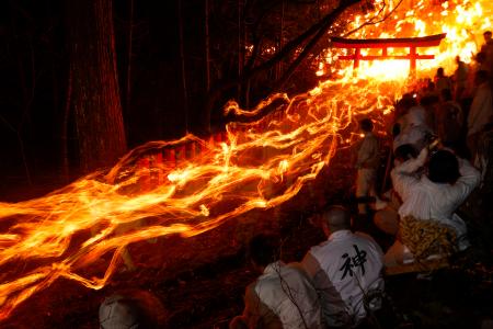 　燃えさかるたいまつを手に男衆が参道を駆け降りる、神倉神社の伝統の火祭り「お灯まつり」＝６日夜、和歌山県新宮市（８秒間露光）