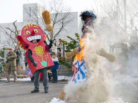 　ロシア極東連邦総合大函館校で行われた、わら人形燃やして春の訪れを祈るロシア式の祝祭「マースレニツァ」。左は春の神「ヤリーロ」＝１０日午前、北海道函館市
