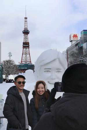 　「さっぽろ雪まつり」最終日、大谷翔平選手の雪像の前で記念撮影をする人たち＝１１日午後、札幌・大通公園