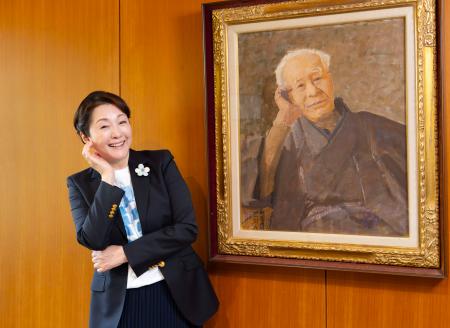 　植物学者牧野富太郎の肖像画の前でポーズをとる松坂慶子さん＝１３日午後、高知市