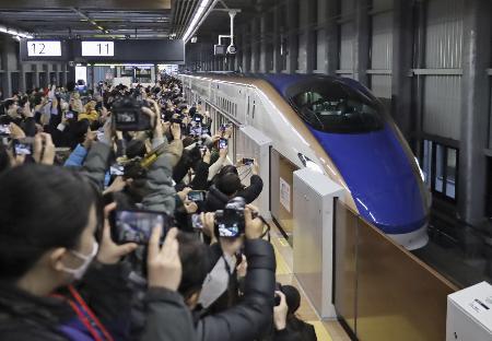 　北陸新幹線が延伸開業し、ＪＲ福井駅に到着した東京行きの一番列車「かがやき５０２号」を出迎える大勢の人たち＝１６日午前