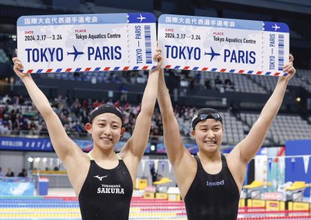 　女子２００メートルバタフライでパリ五輪代表に決まり、ボードを掲げる三井愛梨（左）と牧野紘子＝東京アクアティクスセンター