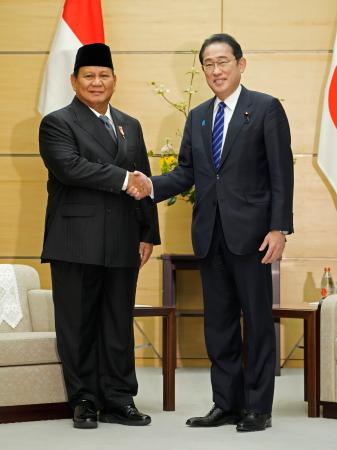 　インドネシア次期大統領のプラボウォ国防相（左）と握手する岸田首相＝３日午前、首相官邸