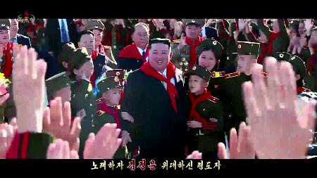 　「親しいオボイ」の一場面で、子どもたちと触れ合う北朝鮮の金正恩朝鮮労働党総書記（中央）。朝鮮中央テレビが１７日放映した（共同）