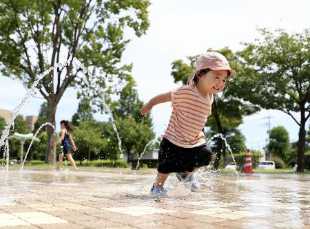　公園の噴水で遊ぶ子ども＝２０２２年