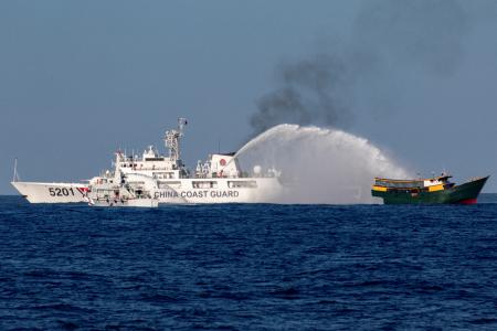 　南シナ海のアユンギン礁で、フィリピンの補給船に放水する中国艦船＝３月５日（ロイター＝共同）