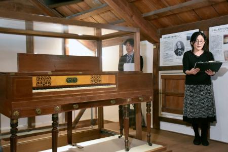 　熊谷美術館に残る、シーボルトから贈られたピアノ。右は江口伊織館長＝４月、山口県萩市
