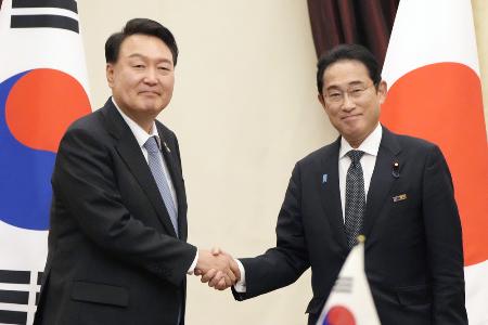 　握手する韓国の尹錫悦大統領（左）と岸田首相＝２０２３年７月、リトアニア・ビリニュス（共同）