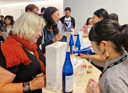 　２２日、ロンドンで開かれた能登半島地震復興支援イベントで石川県産の日本酒を試飲する来場者ら（共同）