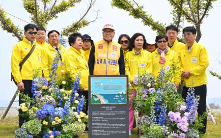 　２４日、韓国南西部・仙遊島に設置されたモニュメントを前に写真に納まる韓国人拉致被害者の家族ら（共同）