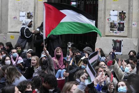 　パリ政治学院の外でパレスチナの旗を振る学生＝４月、パリ（ＡＰ＝共同
