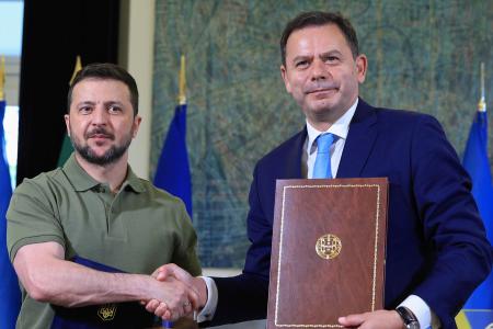 　２８日、ポルトガルの首都リスボンで２国間協定に署名し握手するモンテネグロ首相（右）とウクライナのゼレンスキー大統領（ＡＰ＝共同）