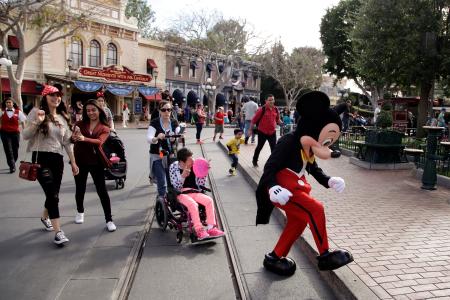 　ディズニーランドで写真を撮るためミッキーマウスを追いかける人たち＝米カリフォルニア州アナハイム（ＡＰ＝共同）