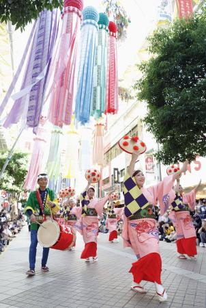 　仙台市で開幕した「東北絆まつり」で披露された山形花笠まつり。仙台七夕まつりの飾り付けの下、大勢の見物客でにぎわった＝８日午後