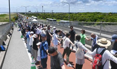 　千葉県九十九里町などを通る有料道路で開かれた、「手首をつないだ人の最も長い列」でギネス世界記録の更新に挑むイベント＝１５日午前