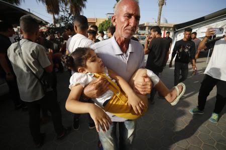 　イスラエル軍によるパレスチナ自治区ガザ中部ブレイジ難民キャンプへの攻撃後、病院に運び込まれる負傷者ら＝１６日（ゲッティ＝共同）