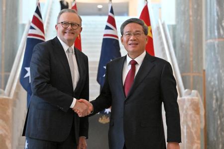 　握手するオーストラリアのアルバニージー首相（左）と中国の李強首相＝１７日、キャンベラ（ロイター＝共同）