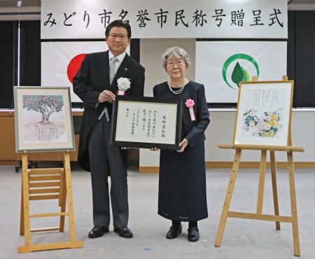 　星野富弘さんに名誉市民称号を贈った群馬県みどり市の須藤昭男市長。右は証書を受け取った妻の昌子さん＝１８日午後、みどり市役所