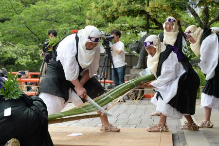 　鞍馬寺の「竹伐り会式」で、大蛇に見立てた青竹をたたき切る僧兵姿の男性ら＝２０日午後、京都市左京区
