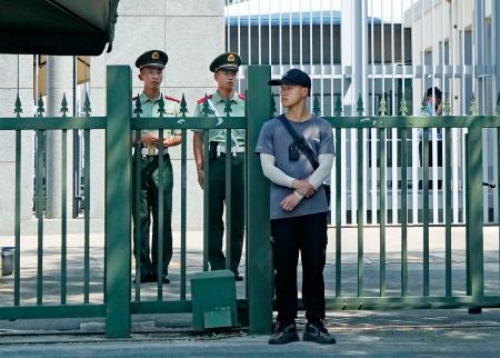 　北京の日本大使館前で警戒する治安当局者ら＝２５日（共同）