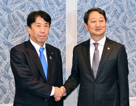 　会談前に握手をする斎藤経産相（左）と韓国の安徳根産業通商資源相＝２６日、米ワシントン（共同）