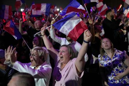 　フランス国民議会総選挙の第１回投票で、国民連合（ＲＮ）の大躍進を伝える開票速報に沸き上がる支持者たち＝３０日、エナンボーモン（ＡＰ＝共同）