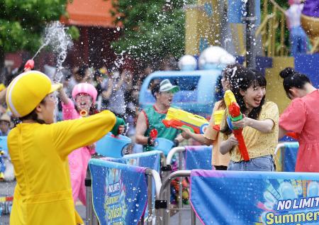 　報道関係者に公開されたＵＳＪの夏のイベントで、水をかけ合う招待客ら＝２日午前、大阪市