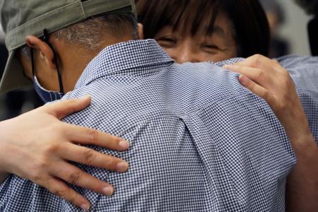 　難民不認定処分を巡る訴訟の判決後、支援者（奥）と抱き合う北アフリカ出身の男性＝４日午後、大阪市