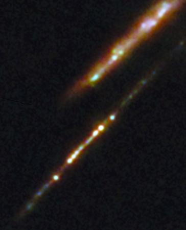 　ジェームズ・ウェッブ宇宙望遠鏡によって、地球から１３３億光年離れた銀河（下）の中に見つかった星団（ＥＳＡ／Ｗｅｂｂ，ＮＡＳＡ＆ＣＳＡ，Ｌ．Ｂｒａｄｌｅｙ，Ａ．Ａｄａｍｏ提供）