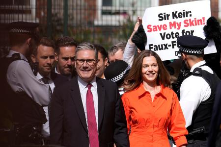 　４日、ロンドンの投票所を妻と訪れた労働党のスターマー党首（手前左）（ＡＰ＝共同）