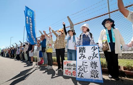 　米軍キャンプ・シュワブのフェンス沿いで手をつなぎ「人間の鎖」をつくる人たち＝６日午前、沖縄県名護市辺野古